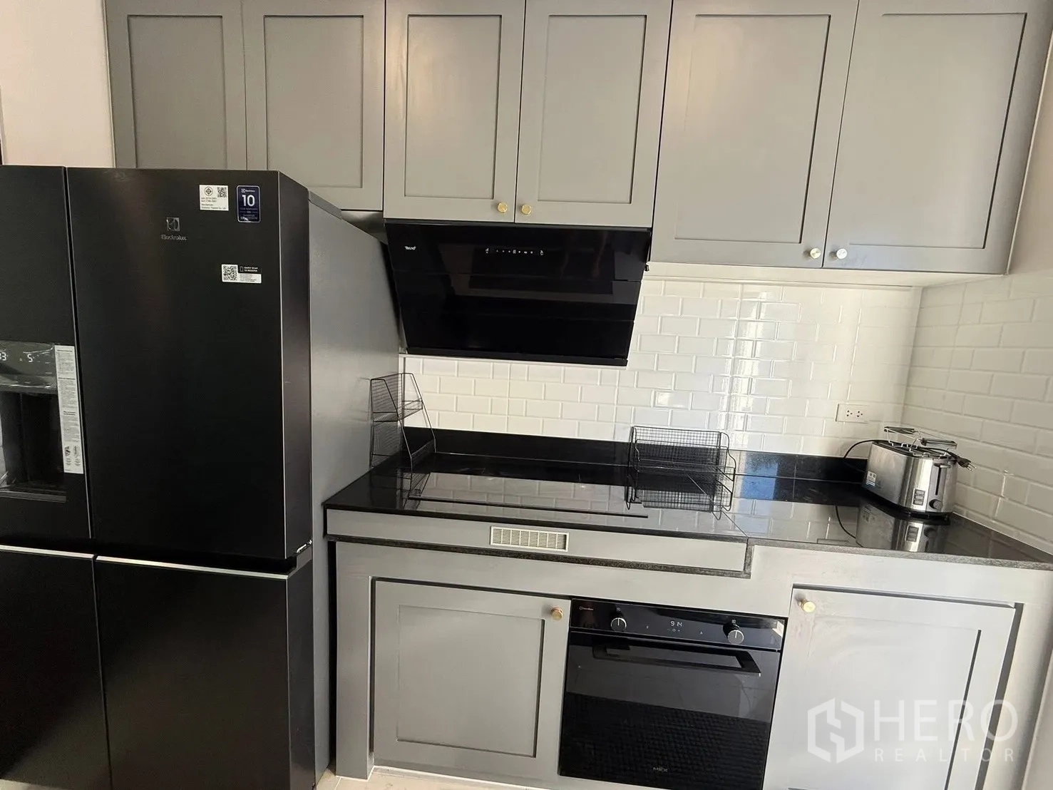 บ้านเดี่ยว for rent in Bang Phli, Samut Prakan - มุมครัวบิวท์อินอีกด้านพร้อมผนังกระเบื้องซับเวย์และเครื่องใช้ไฟฟ้า.