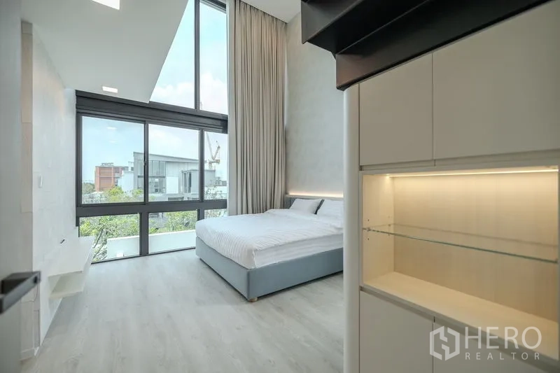 Detached House for rent in Saphan Sung, Bangkok - Bedroom with full-height windows bringing in abundant natural light and views.