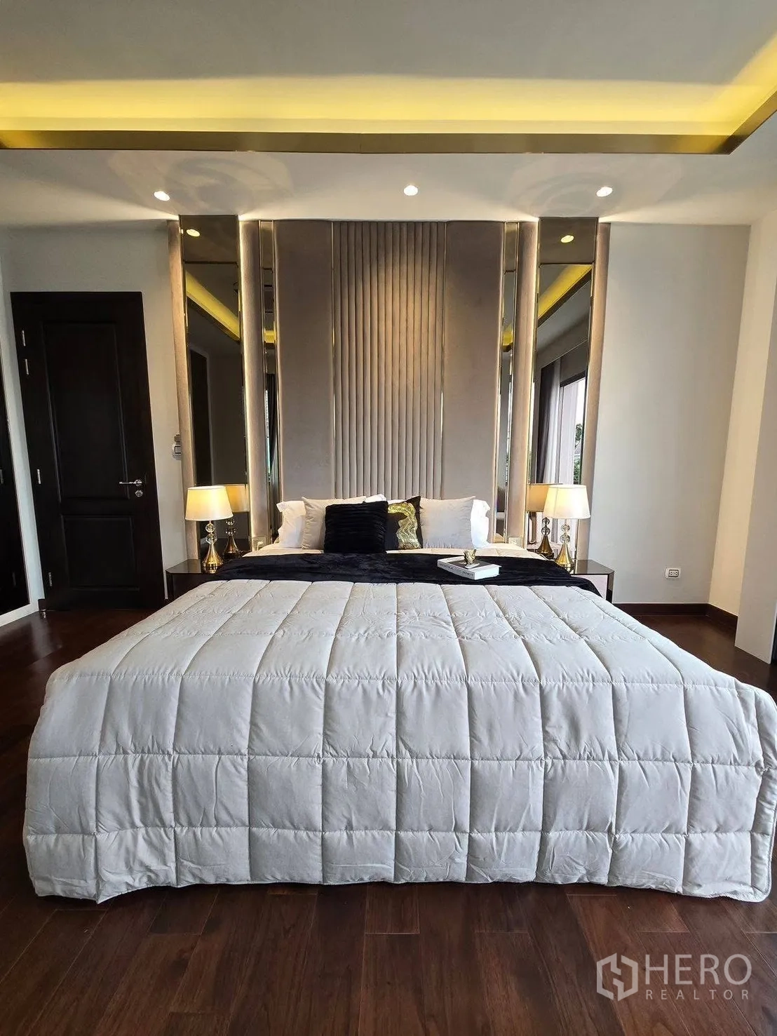 บ้านเดี่ยว for rent or sale in Bang Phli, Samut Prakan - มุมหน้าห้องนอนหัวเตียงบุผ้า โคมไฟหัวเตียง และไฟเพดานนุ่มนวล