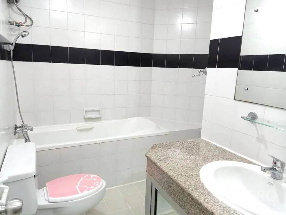 Condominium for rent in Watthana, Bangkok - Bathroom with bathtub, vanity with sink, mirror, and toilet.