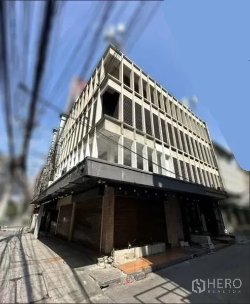 Retail Space for rent in Khlong Toei, Bangkok - Corner view of a multi-storey commercial building with grid facade and wraparound awning.