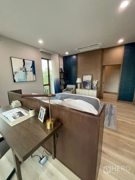 Detached House for sale in Bang Kapi, Bangkok - Master bedroom suite with study desk, wood paneling and large windows.