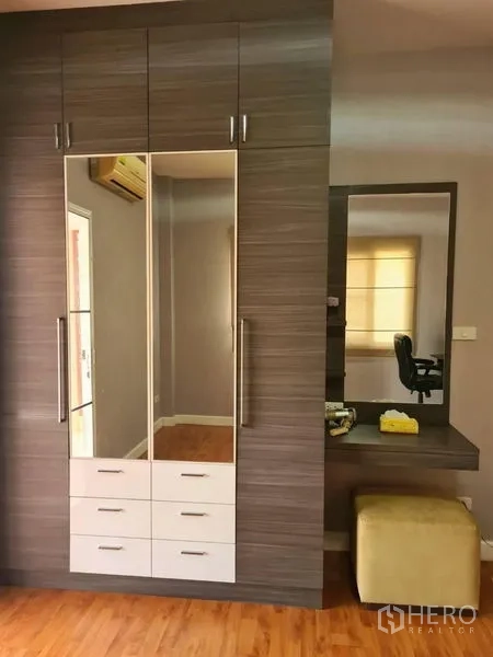 Detached House for rent in Sai Mai, Bangkok - Built-in wardrobe with mirrored doors next to a vanity desk and stool.