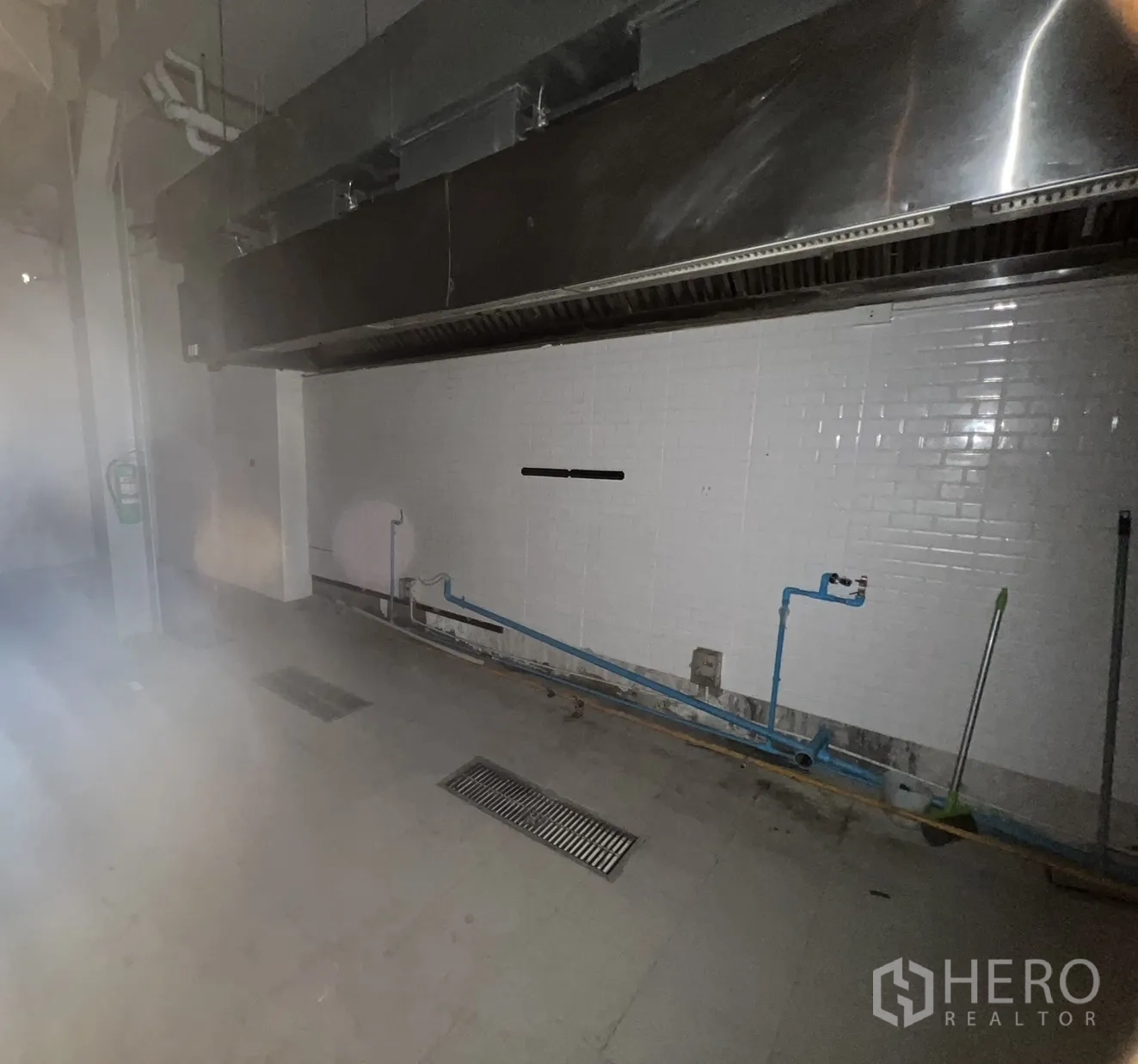 Retail Space for rent in Watthana, Bangkok - Commercial kitchen wall with stainless exhaust hood, floor drains and plumbing connections.