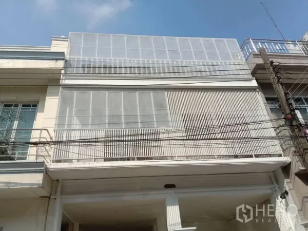 Townhouse for rent in Phra Khanong, Bangkok - Modern three-storey townhouse facade with white metal screens in Phra Khanong near BTS Bang Chak.