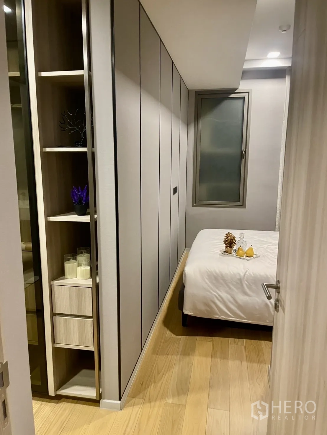 公寓 出租在Watthana, Bangkok - 通往卧室的狭长走廊，开放格架与窗户。