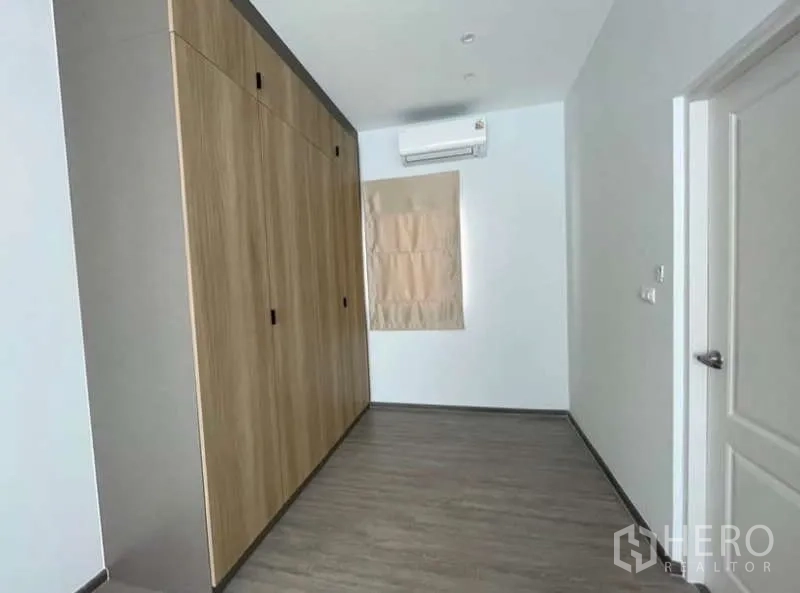 Detached House for rent in Bang Phli, Samut Prakan - Room with floor-to-ceiling built-in wooden wardrobes and air conditioning.