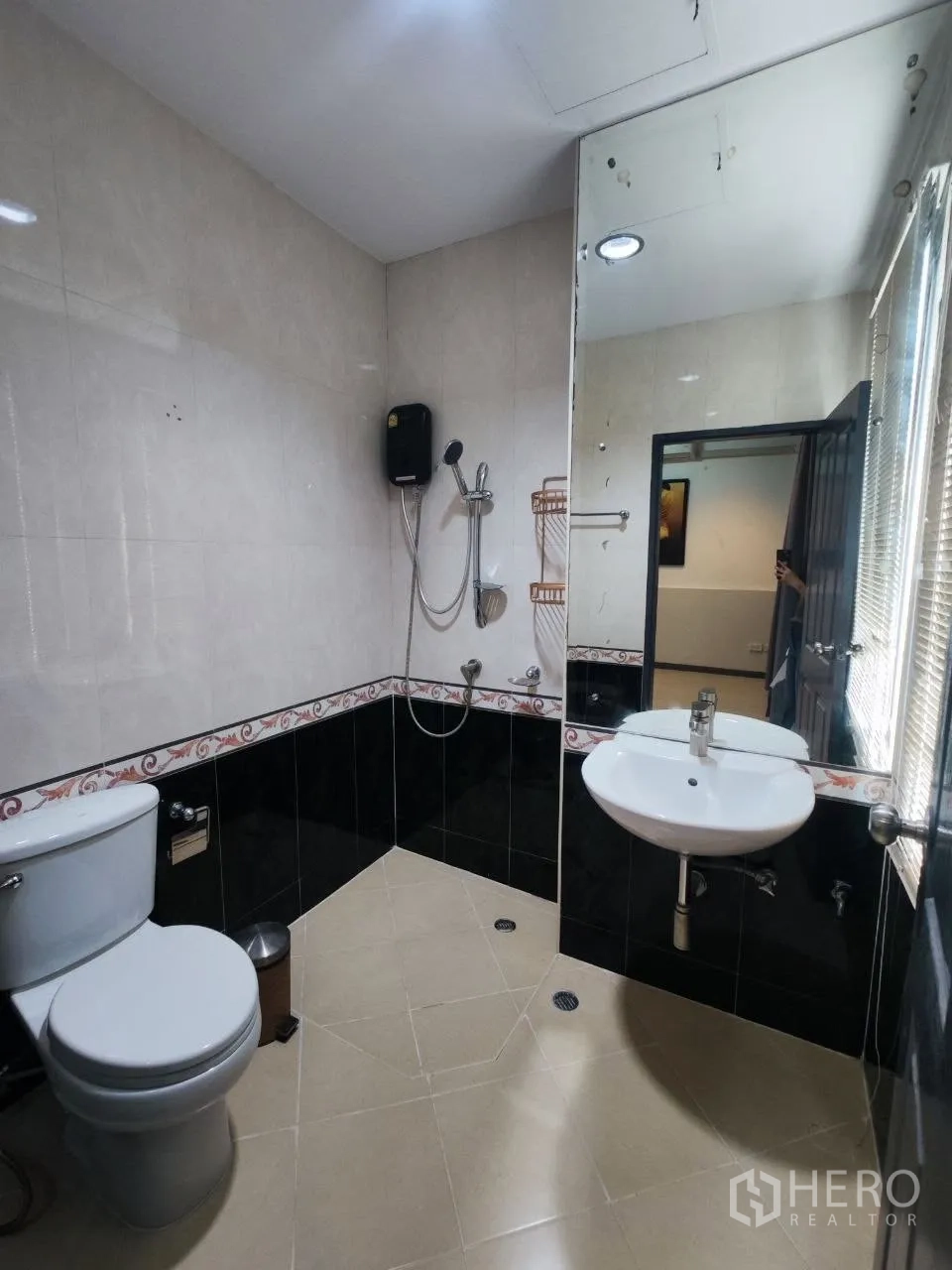 Home Office for rent in Bang Na, Bangkok - Tiled bathroom with wall mirror, toilet, hand shower and basin.