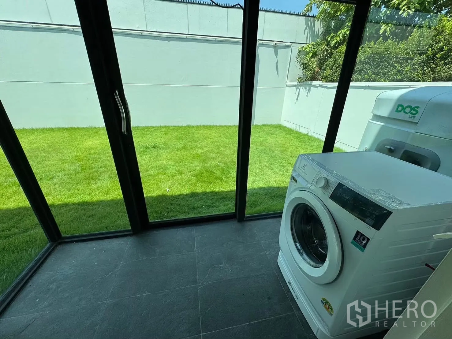 Detached House for rent in Prawet, Bangkok - Glass laundry room with washing machine overlooking the garden.