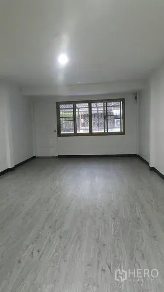 店屋 出租在Watthana, Bangkok - 二层宽敞房间，正面大窗与明亮顶灯。