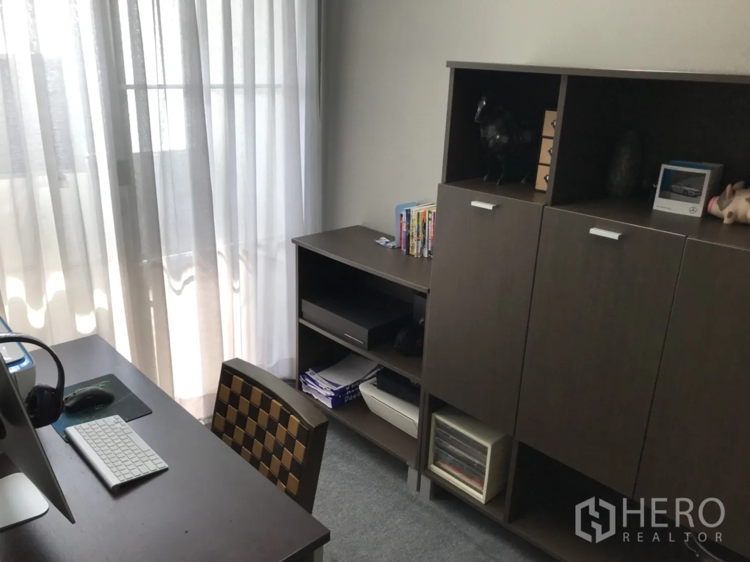 公寓 出租在Watthana, Bangkok - 采光良好的书房，配有书桌、电脑与深色木质收纳柜，临纱帘阳台。