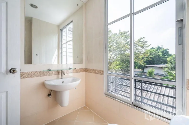 Townhouse for sale - Bathroom with vanity and a large window offering garden views.