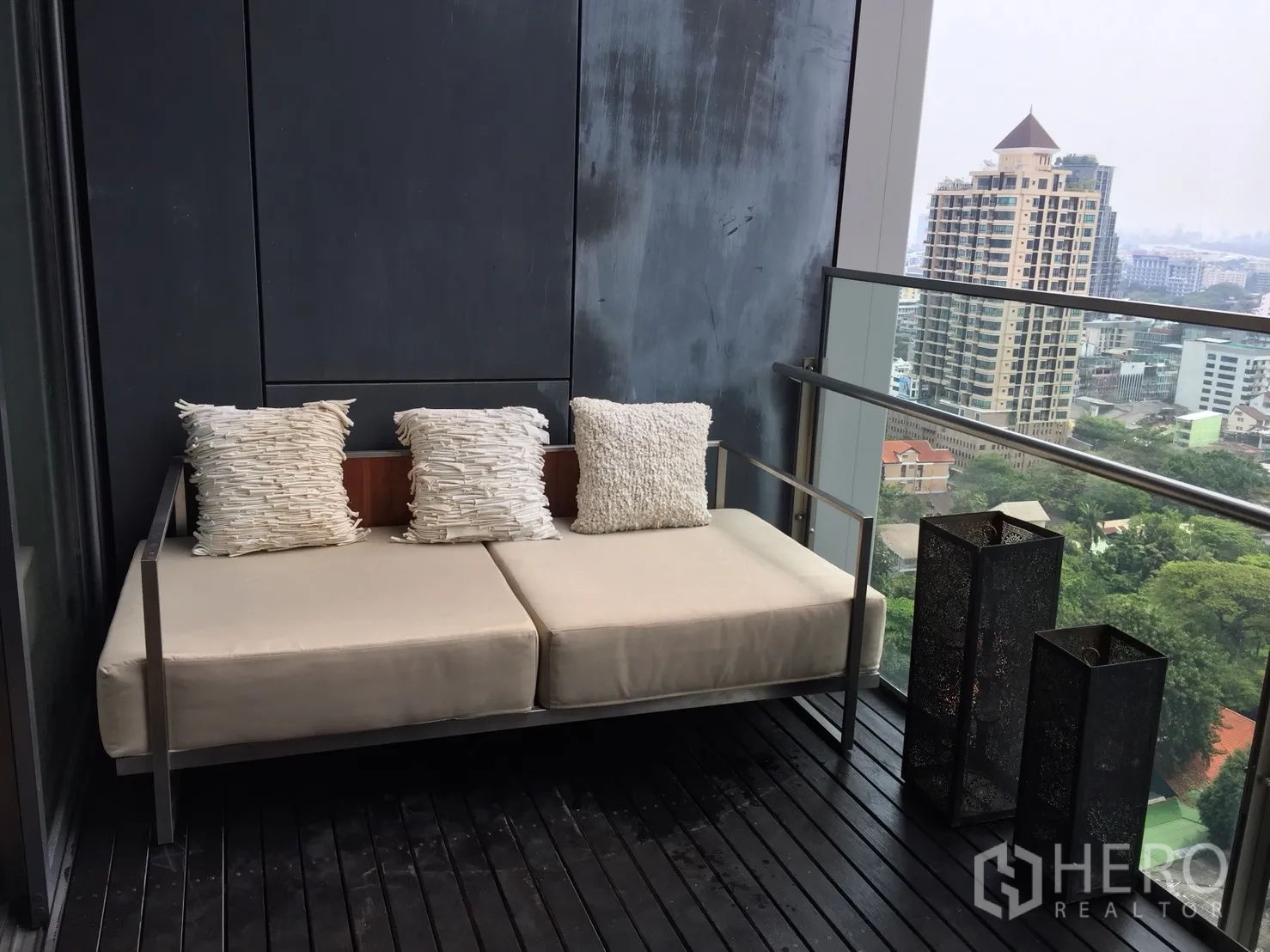 Condominium for rent or sale in Sathon, Bangkok - Private balcony with cushioned bench and open city and park views.
