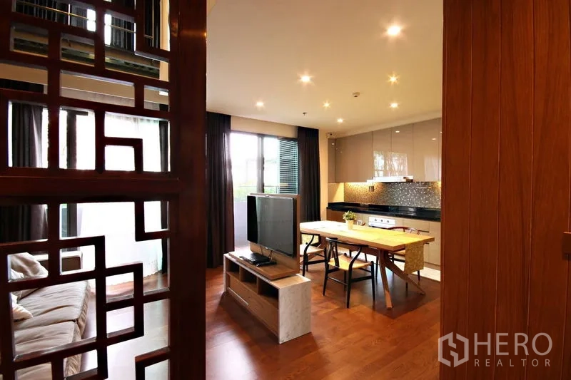 Condominium for rent or sale in Khlong Toei, Bangkok - Decorative lattice screen framing a view to the open-plan living and kitchen.