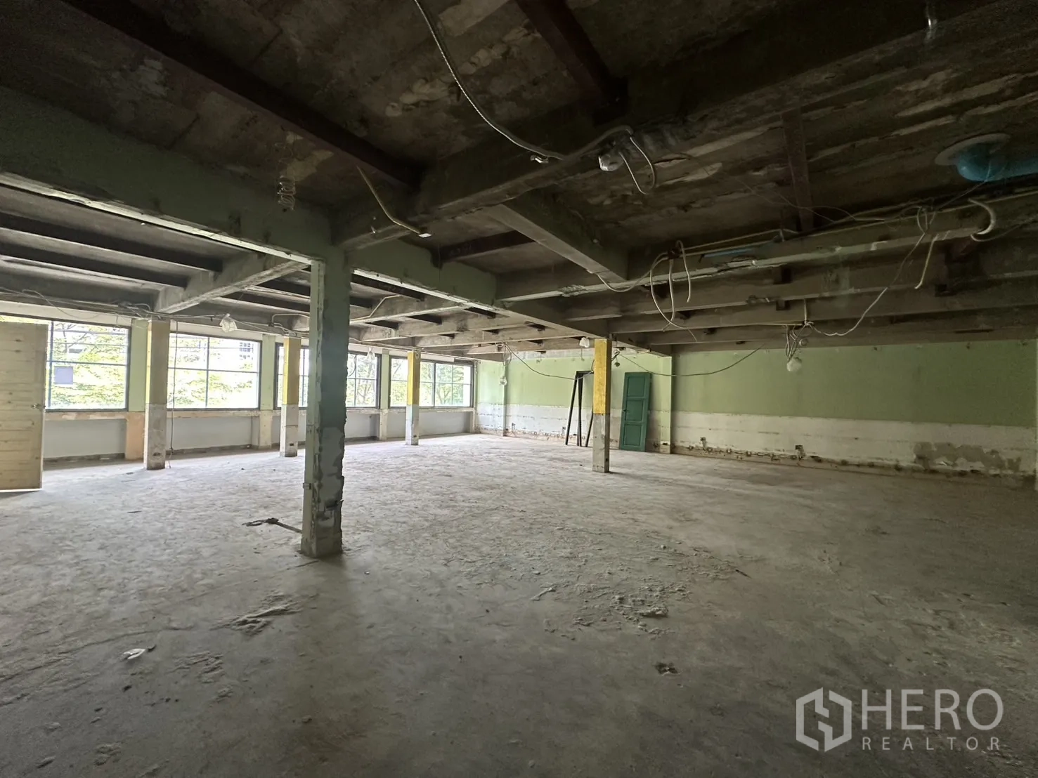 Office Space for rent in Bang Rak, Bangkok - Deep view of the bare office floor highlighting columns and a long run of windows.