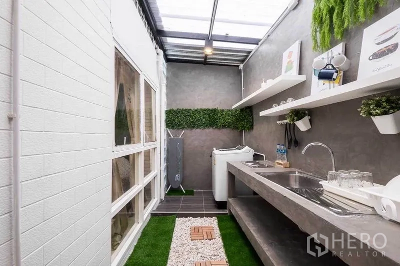 Detached House for rent in Khlong Toei, Bangkok - Semi-outdoor kitchen with skylight roof, double sink, open shelves and pebble path.