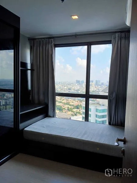 Condominium for rent - Second bedroom with single bed, built-in storage and wide city views.