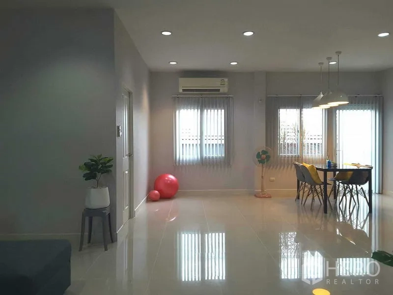 Detached House for rent in Lam Luk Ka, Pathum Thani - Dining corner by windows with blinds and hanging lamps in an airy space.