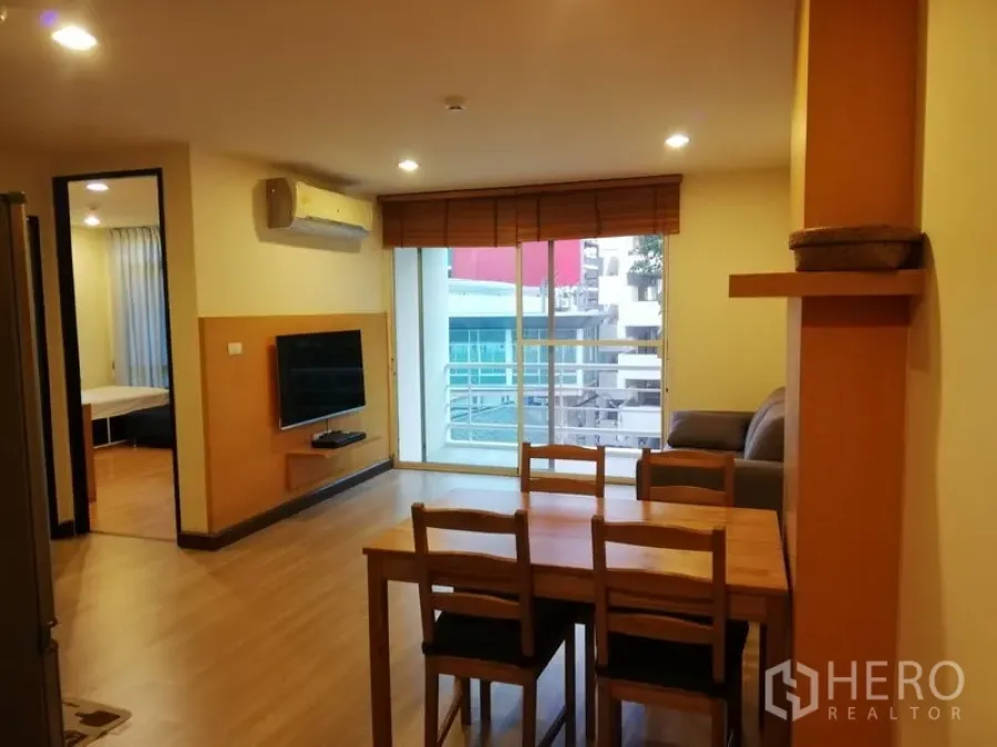 公寓 出租在Watthana, Bangkok - 餐客一体空间，墙挂电视与宽阳台，城市景观，近BTS澎蓬站。
