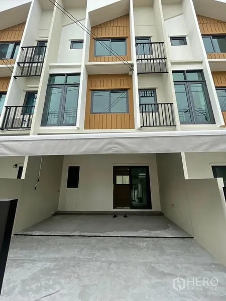 联排别墅 出租在Prawet, Bangkok - 曼谷Prawet区三层联排别墅外立面，带双车位有顶车库和小阳台。