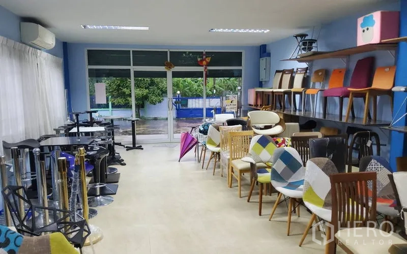 Warehouse for sale in Mueang Nonthaburi, Nonthaburi - Showroom area with chairs on display and a full-height glass entrance.