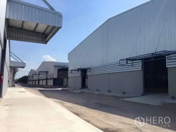 Warehouse for rent in Bang Pa-in, Phra Nakhon Si Ayutthaya - Row of warehouses with raised loading platforms, canopies, and concrete aprons for truck maneuvering.