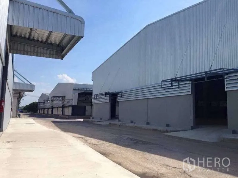 Warehouse for rent in Bang Pa-in, Phra Nakhon Si Ayutthaya - Row of warehouses with raised loading platforms, canopies, and concrete aprons for truck maneuvering.