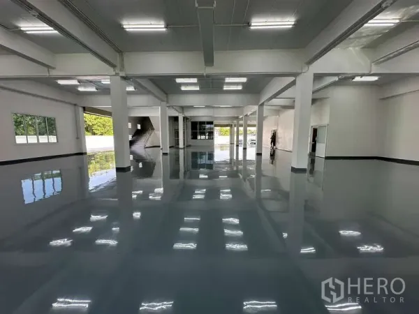 货栈 出租在Mueang Samut Prakan, Samut Prakan - 环氧地坪仓库大厅，顶高开阔，立柱与明亮LED照明。