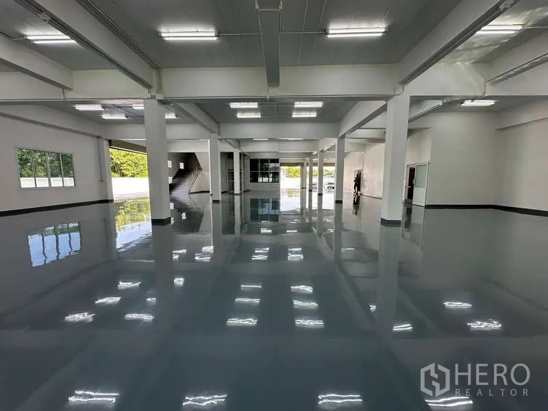 货栈 出租在Mueang Samut Prakan, Samut Prakan - 环氧地坪仓库大厅，顶高开阔，立柱与明亮LED照明。