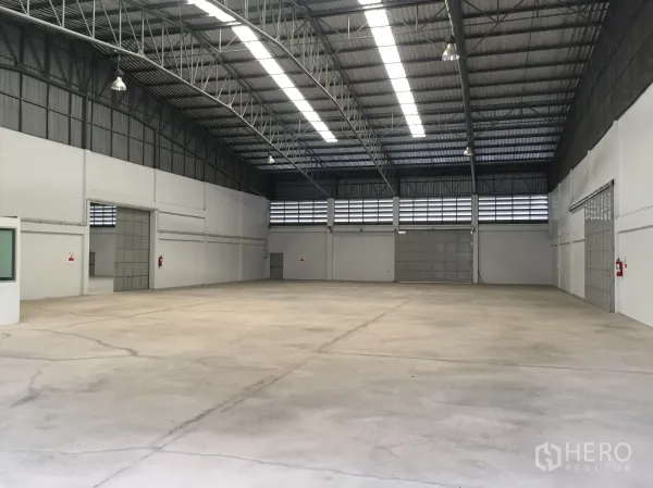 โรงงาน ให้เช่าในSi Racha, Chon Buri - ภายในโกดังโล่งกว้าง เพดานโครงเหล็กสูง มีสกายไลต์ ช่องลม และพื้นคอนกรีตในโรงงานศรีราชา