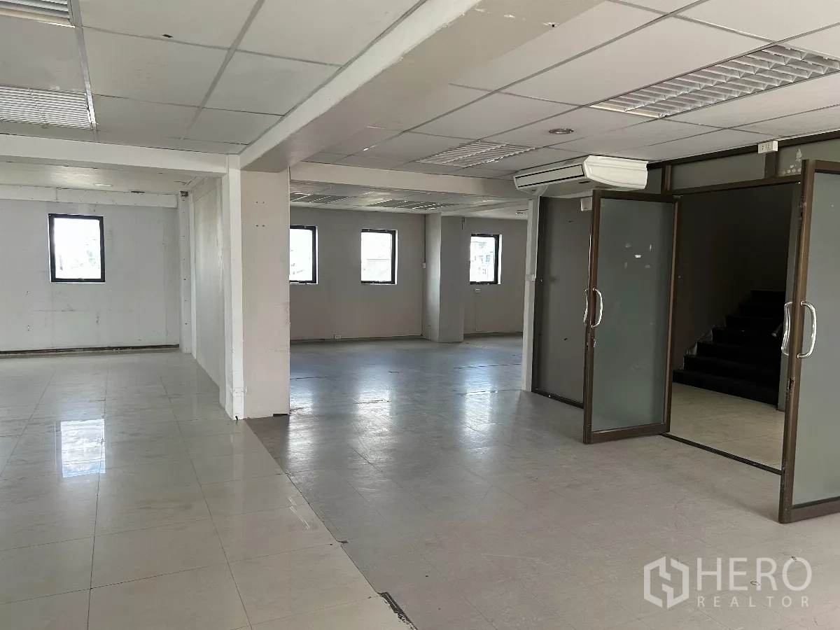 办公空间 出租在Din Daeng, Bangkok - 宽敞办公室内部，带玻璃隔门、空调与楼梯。