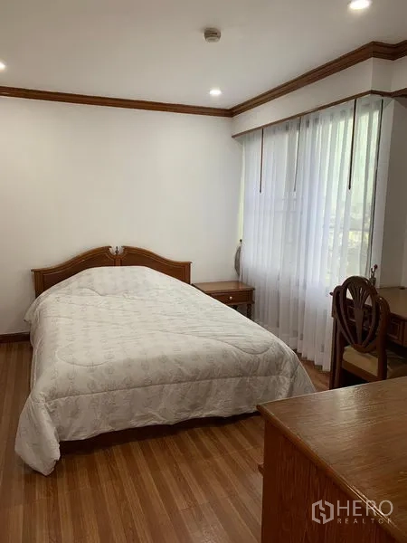 公寓 出租在Watthana, Bangkok - 第二卧室带书桌、衣柜与大窗薄纱窗帘，坐落曼谷瓦塔那区的 Liberty Park 1。
