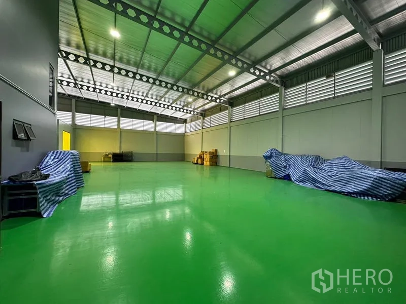 工厂 出租或出售在Lam Luk Ka, Pathum Thani - 宽敞生产车间，绿色环氧地坪，钢桁架屋顶与百叶通风窗。