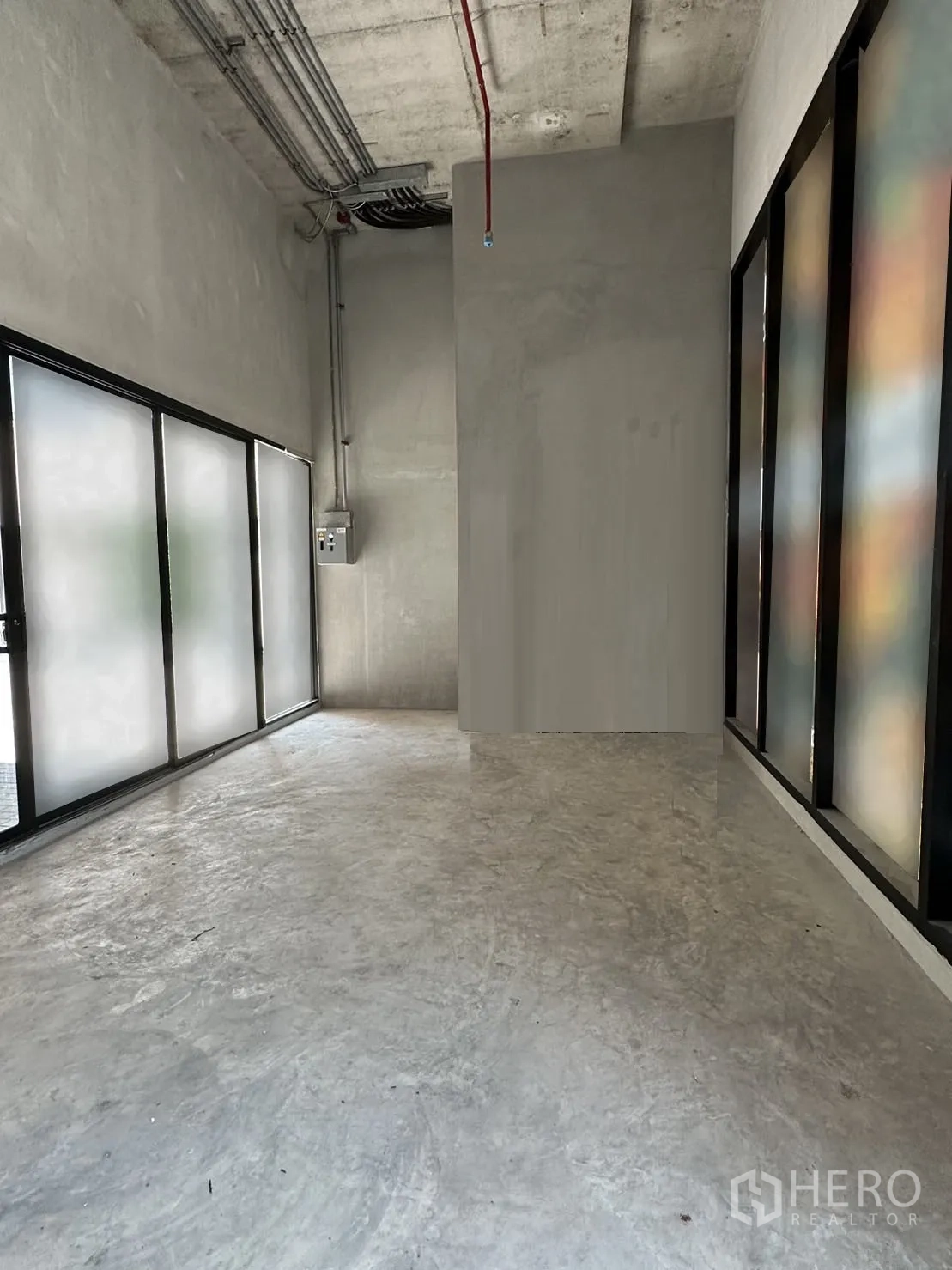 零售空间 出租在Khlong Toei, Bangkok - 狭长型商铺，整面磨砂玻璃橱窗与高挑外露管线天花。