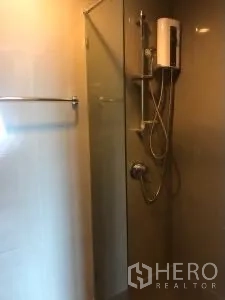 Condominium for rent or sale in Khlong Toei, Bangkok - Glass-enclosed shower with water heater and handheld shower set.