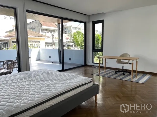 独栋房屋 for rent in Watthana, Bangkok - 大卧室带书桌、地毯，可通往超大露台。