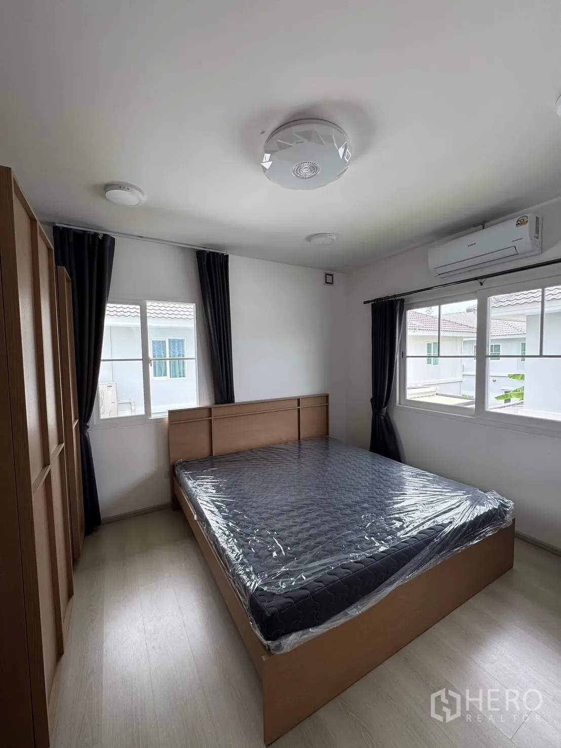 Detached House for rent in Bang Phli, Samut Prakan - Bedroom with wooden bed, matching wardrobe, and air conditioning.