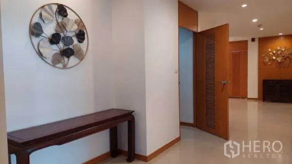 Apartment for rent - Clean hallway and entry with console table and decorative wall piece in the Sathon apartment.