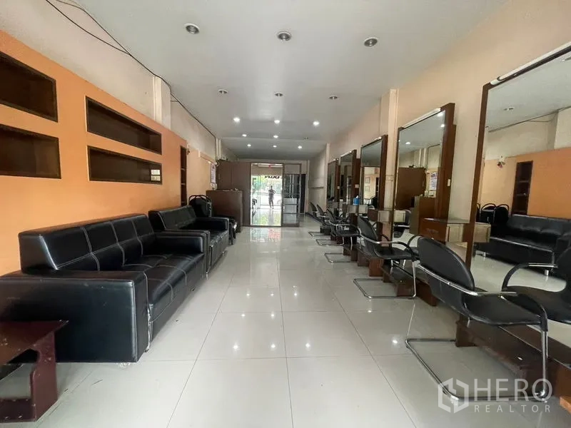 Shophouse for rent in Phra Khanong, Bangkok - Long salon-style layout with mirrors, styling chairs and recessed lighting.