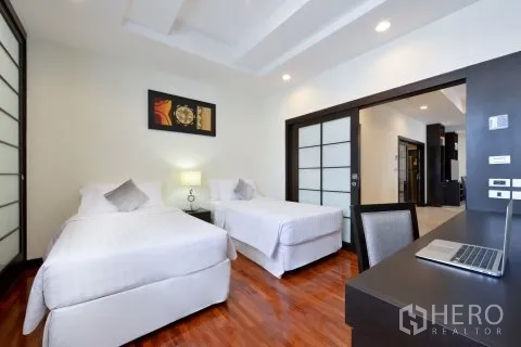 公寓 for rent in Watthana, Bangkok - 双床卧室，设书桌与推拉门，木地板光亮。
