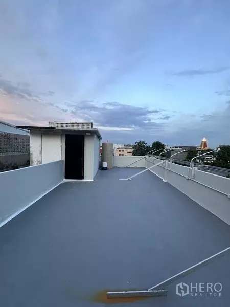 Shophouse for rent - Spacious rooftop terrace at dusk with access door on a commercial shophouse building.