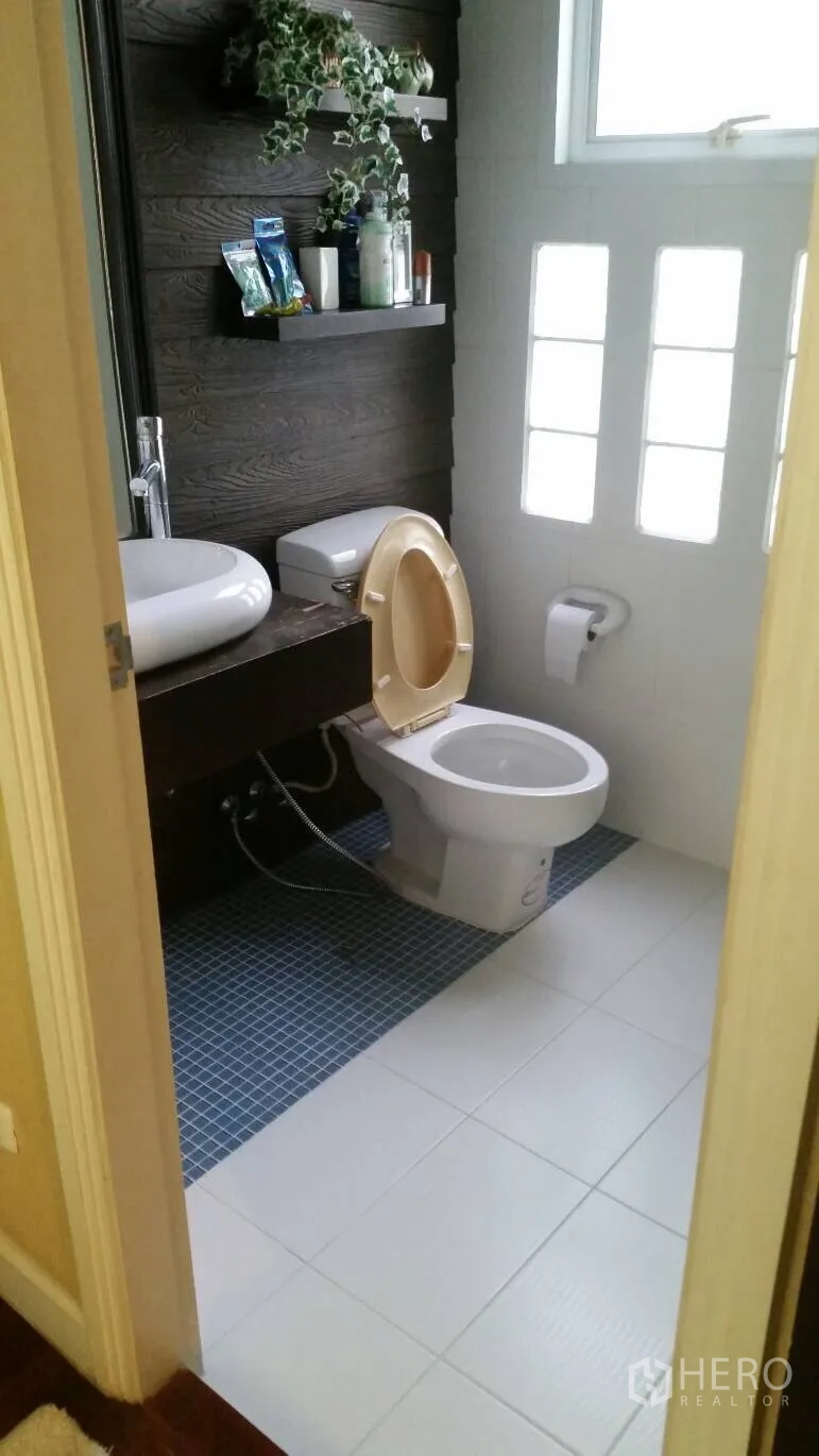 Detached House for rent in Lat Krabang, Bangkok - Bright bathroom with toilet, vessel sink, dark accent wall, and window.