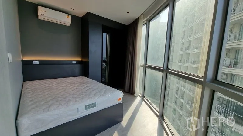 公寓 出售在Watthana, Bangkok - 卧室配大窗、定制床架与壁挂空调。
