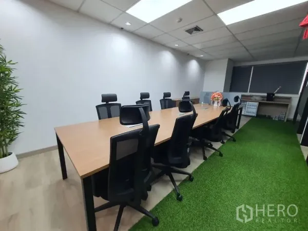 สำนักงาน ให้เช่า - ห้องประชุมยาว โต๊ะประชุมไม้ เก้าอี้ทำงานแบบ Ergonomic และทางเดินหญ้าเทียม