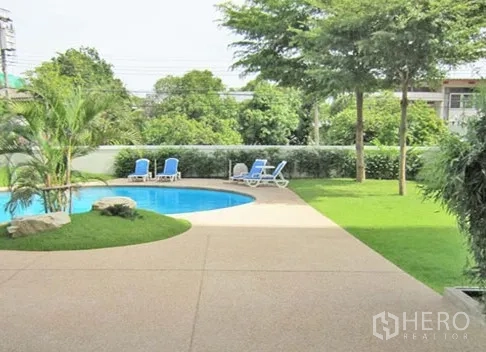 Apartment for rent in Khlong Toei, Bangkok - Pool deck with curved path, lawn and shade trees beside the swimming pool
