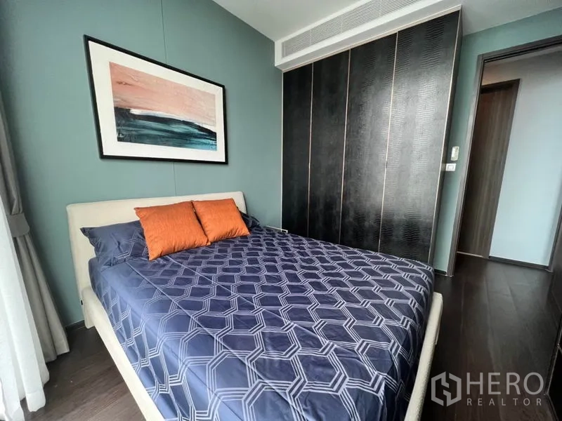 คอนโด ให้เช่าในWatthana, Bangkok - ห้องนอนที่สองเตียงคู่ ภาพแขวน หมอนสีส้ม และตู้เสื้อผ้าบิวท์อินเต็มสูง