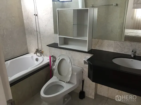 Condominium for rent in Watthana, Bangkok - Bathroom featuring a bathtub, large mirror and black stone vanity.