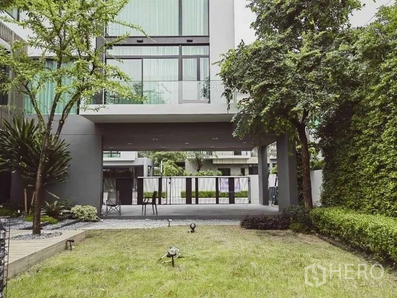独立式住宅 出租 - 草坪花园通向挑空上层下的有顶车位，四周绿篱环绕。