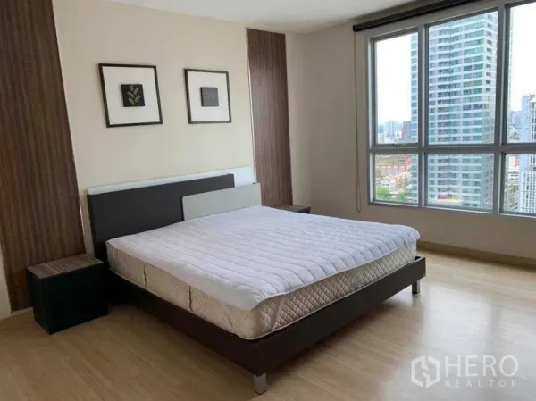 Condominium for rent in Bang Rak, Bangkok - Master bedroom from another angle showing floor-to-ceiling windows and skyline view.