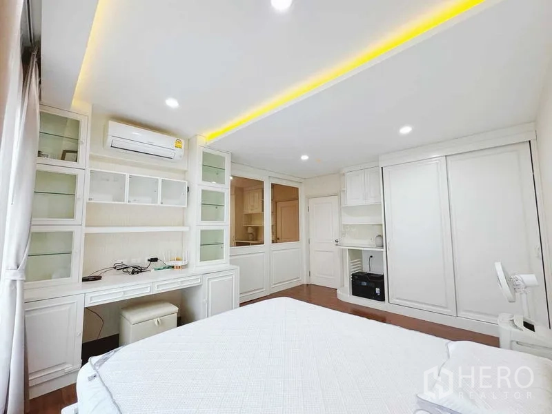 Townhouse for rent in Phra Khanong, Bangkok - Master suite angle showing wall-to-wall cabinetry and study desk.